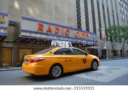 New York City, USA - September 7, 2015: Taxi cab passing in front of Radio City Music Hall in midtown Manhattan in New York City.