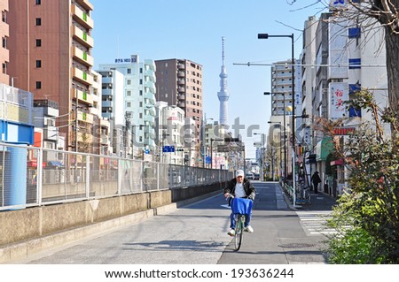 TOKYO - APRIL 04: The old man is cycling in the road on April 4, 2014 in Tokyo, Japan. Tokyo is the capital of Japan and one of the most modern cities of the world.