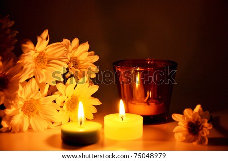 Three candles and flowers on dining table