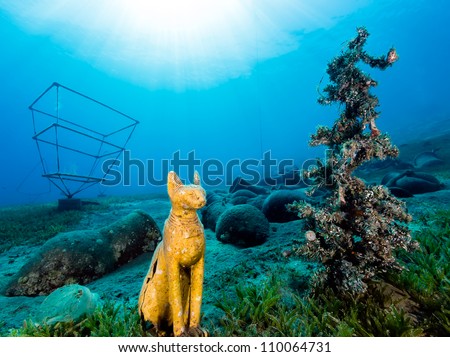 Underwater Christmas Tree and Egyptian Cat statue sit next to each other 12m under the Red Sea in Dahab, Egypt