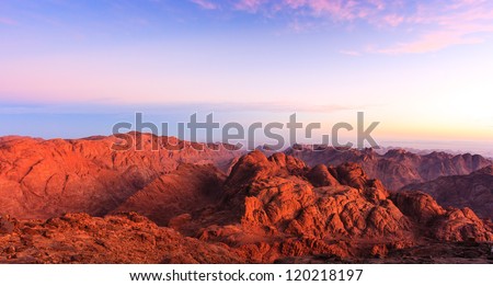 Barren desert mountains illuminated by the rising sun from the top of Mount Sinai
