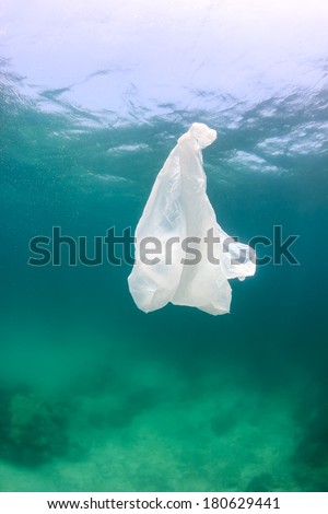 A discarded plastic bag floats over murky, desolate seabed. A sign of human impact on the marine ecosystem