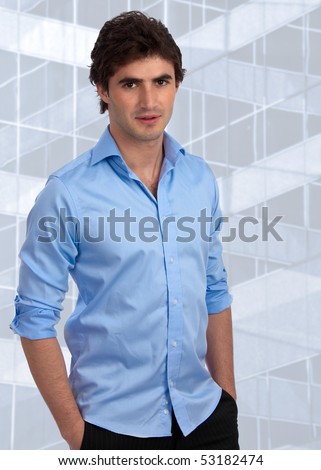 Handsome, young businessman with rolled-up sleeves in an office setting, ready for his career
