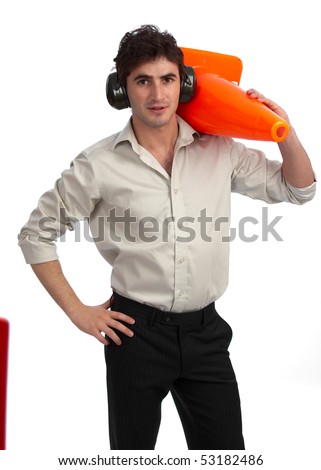 Young, handsome construction foreman with rolled-up sleeves, wearing hearing protection and carrying a traffic cone
