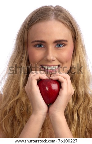 Beautiful blond caucasian young woman smiling and  holding a red apple, creating a heart with her hands