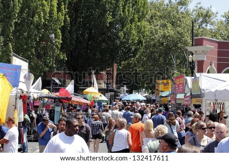 PORTLAND, OREGON - JULY 28: A large crowd of people walking around on a sunny summer day in between many craft vendors at the year round Saturday Market on July 28, 2012 in Portland, Oregon.