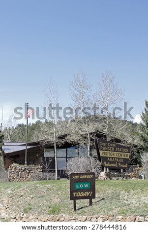 Idaho Springs, CO, USA - April 23, 2014: The Visitor Center and Clear Creek Ranger Station of the  Arapahoe National Forest. Vertical front view of a forest service building with trees, lawn and signs