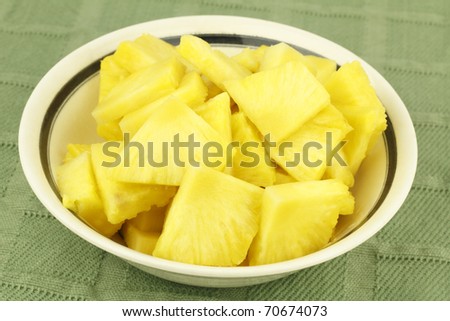 A bowl full of yellow golden tropical fruit in bite size pieces.