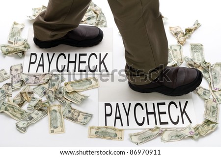 Male legs walking from one paycheck to another with crumpled money scattered about on the floor.
