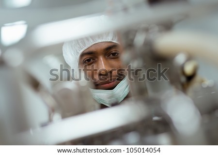 Lab technician working as researcher in biotechnology plant with machinery