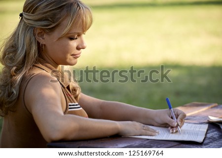 Young women and education, female student studying for college exam in park. Side view, copy space