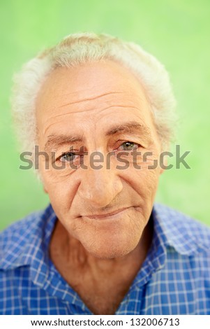 Senior men and feelings, portrait of happy old caucasian man looking at camera on green background