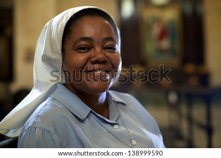 Woman and religion, portrait of catholic nun praying in church and looking at camera
