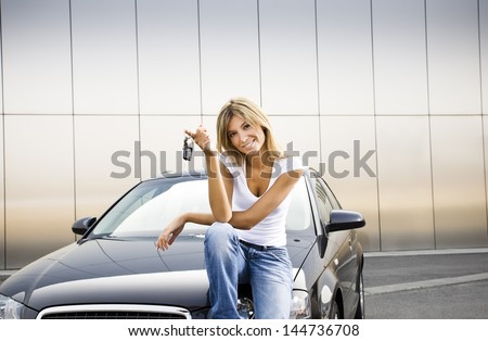 Young Woman Holding Keys To New Car And Smiling At Camera