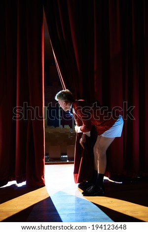 Arts and entertainment in theatre with funny man working as anchorman, standing with pants behind the scenes and looking at pit