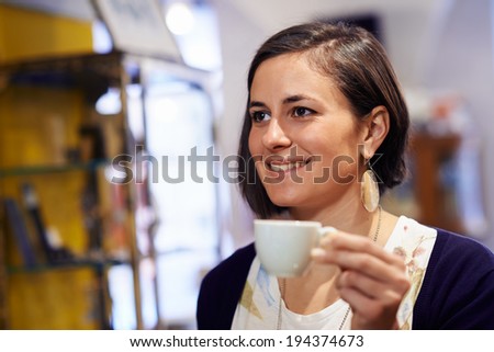 People in cafeteria with woman drinking espresso coffee and holding cup