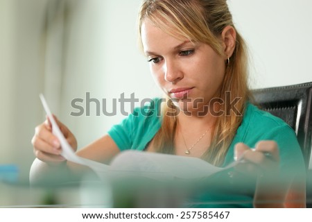 Young blond woman, college student, studying with motivated and concentrated expression