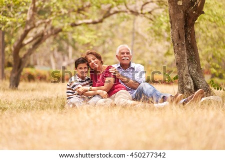 Old people, senior couple, elderly man and woman. Outdoor family having fun with happy grandpa and grandma hugging boy at picnic in park.