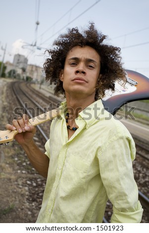 cool guy with his guitar at a train station