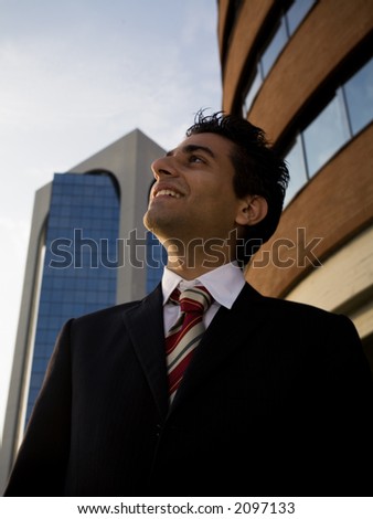 successful businessman staring at the sky and smiling
