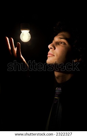 a young actor dressed as a businessman taking a pose in stage lighting
