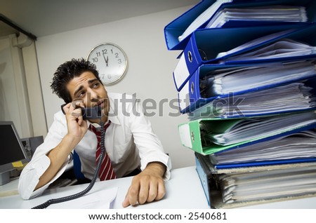 exhausted businessman in his office surrounded by files
