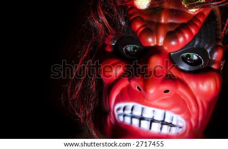 Halloween party: scaring mask against black background