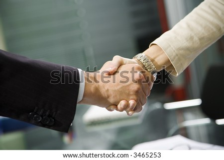 People at work: man and woman hand shaking at a meeting