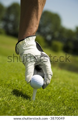Golf club: golfer arranging the ball on the tee