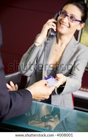 Paying by credit card: young salesclerk smiling at a customer