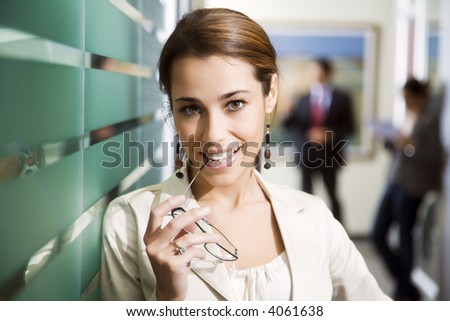 Office life: young business woman looking at the camera smiling