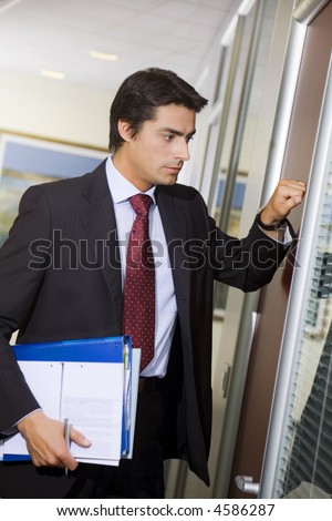 Office life: young employee knocking on his boss door