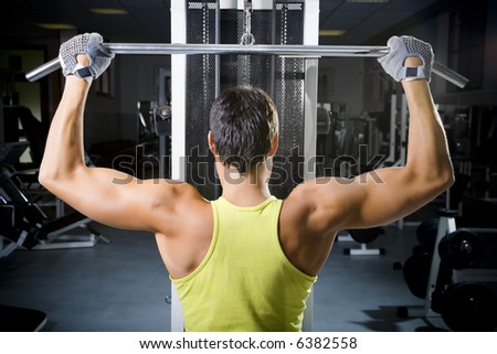 health club man in a gym doing weight lifting health club man in a gym doing weight lifting