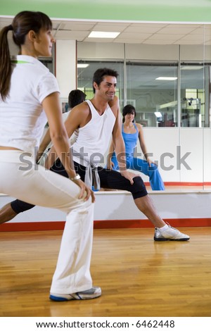 health club: man and women doing stretching and aerobics