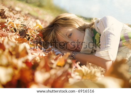 expressing positivity: blond girl resting on autumn leaves