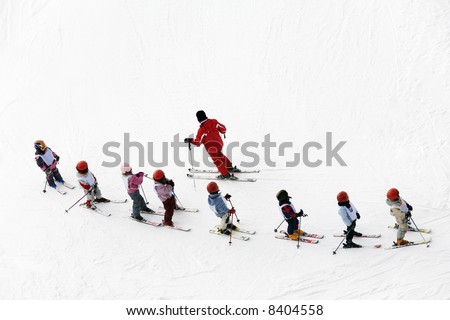 winter scene: kids learning to ski and their instructor