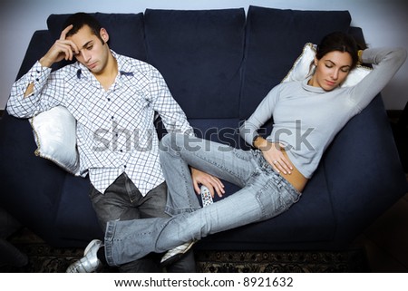 relationship difficulties: bored couple watching tv