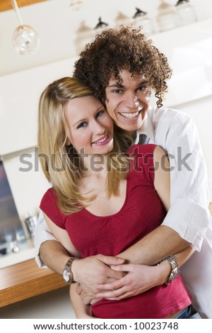 domestic life: happy interracial couple hugging