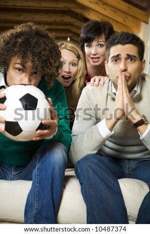 domestic life: group of friends watching a football match on tv
