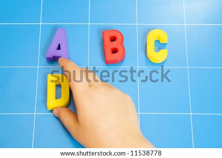 child learning the ABC\'s. The focus is on the letter B