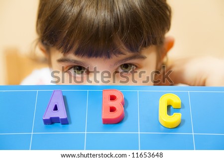 child learning the ABC\'s. The focus is on the letters