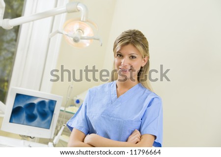young dental assistant smiling. X-ray image on the computer monitor in the background