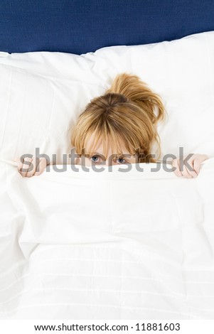 Young woman lying in bed doesn't want to wake up. Copy space