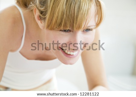 beautiful young woman looking herself in the mirror and smiling
