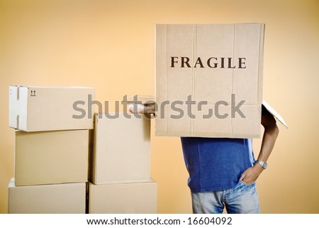Man with fragile box covering head, studio shot