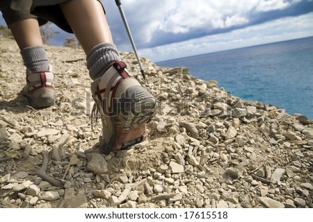 young woman hiking on a cliff near the sea