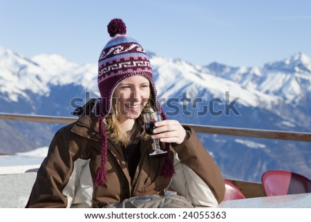 young woman enjoying red wine outdoors in mountain
