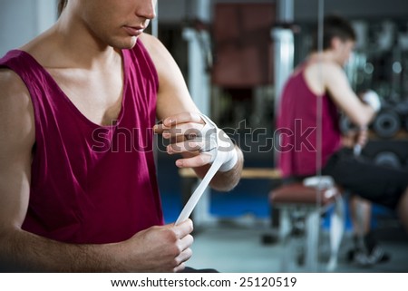 cropped view of boxer wrapping his hands in gym. Copy space