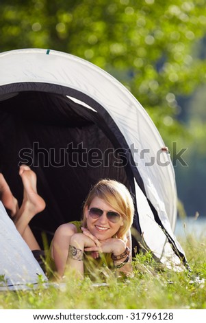 young blonde woman lying in tent with feet crossed. Copy space