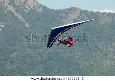 man doing hang-gliding and landing with brake parachute. World air games in Avigliana, Turin, Italy